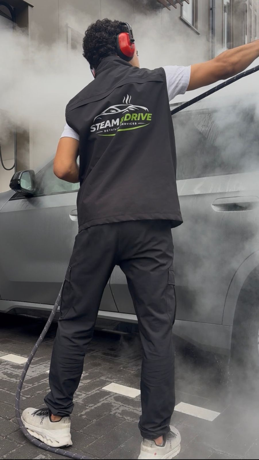 Vakman behandelt een auto met professionele stoomapparatuur
